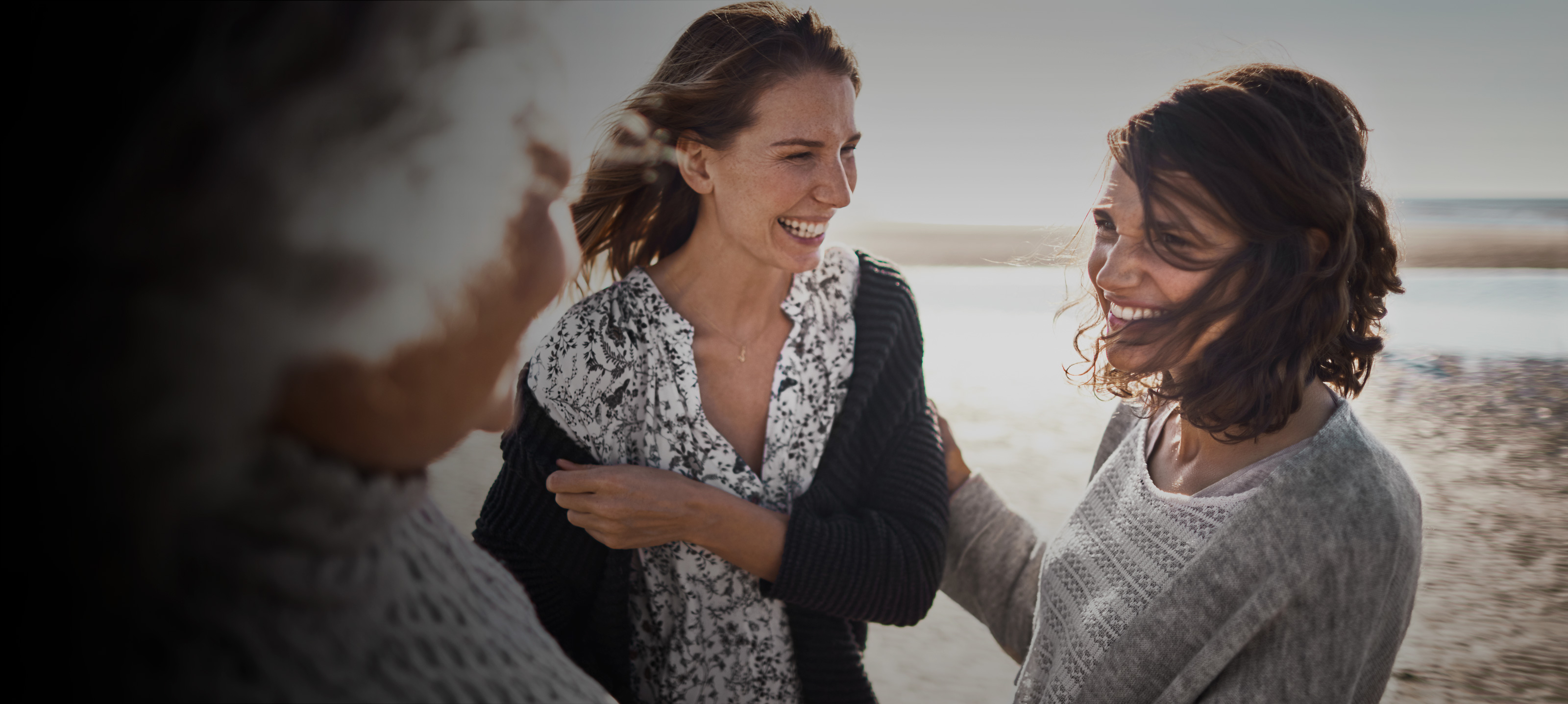 Three females laughing outdoors
